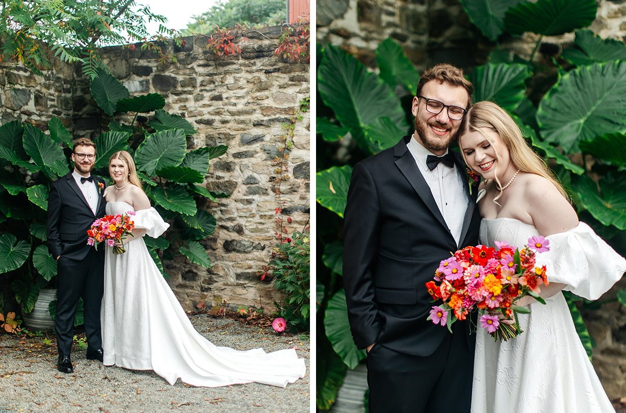 groom and bride holding pink, red, and orange wedding bouquet stand together and laugh in front of tropical greenery at the treman center in newfield NY