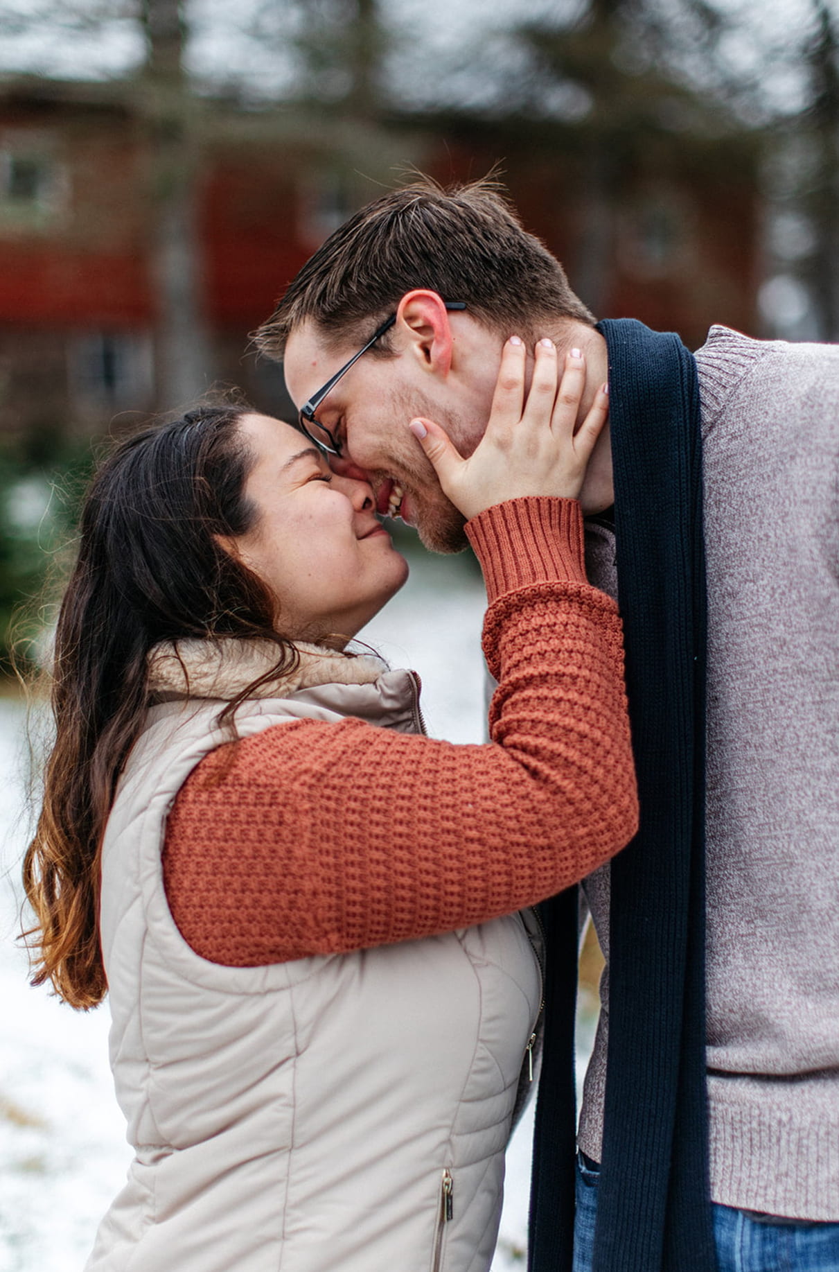 couple almost kisses during their snowy winter engagement session in upstate ny