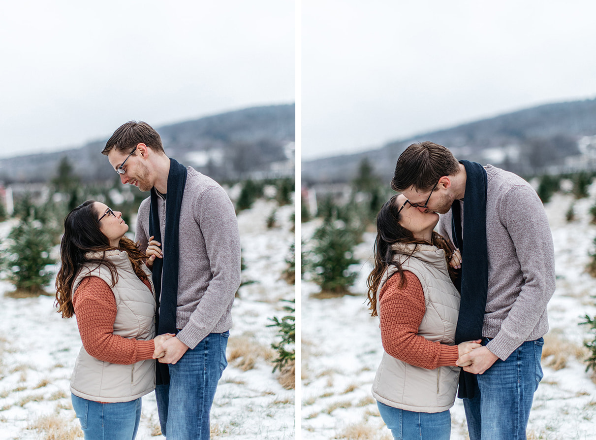 couple embraces during their engagement session in a snowy field of a christmas tree farm