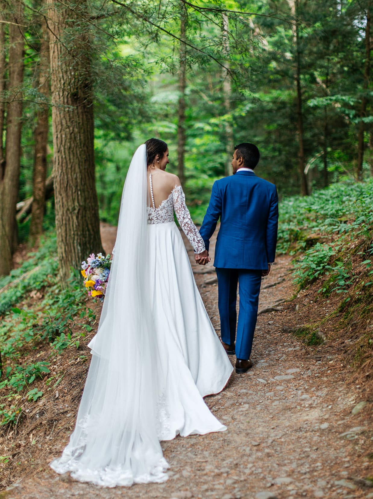 Newly married couple walking through a forest trail after their Upstate New York elopement